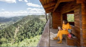 WOMEN WEARING A BRIGHT YELLOW ONE PIECE JUMPSUIT SITTING OUTSIDE HER AIRBNB DURING HER VACATION TO THE ACADIA NATIONAL PARK ON A BEAUTIFUL SUMMER DAY