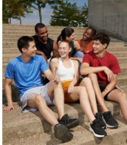 STUDENTS SITTING OUTSIDE OF HARVARD UNIVERSITY, TAKING THEIR VISITORS ON A TOUR OF BOSTON MASSACHUSETTS.