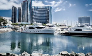 BOATS LINED UP ON THE BEAUTIFUL SAN DIEGO  OCEAN ADJACENT TO A MAJOR HOTEL WITH THE REFLECTION SEEN ON THE PRISTINE BLUE WATERS